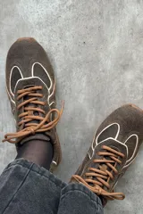Championes deportivos color marrón con diseño de líneas onduladas en tono claro, cordones al tono y suela de goma.