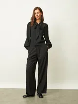 Pantalon de corte recto y holgado, color negro, con cintura elástica y cordón ajustable. Cuenta con bolsillos laterales.