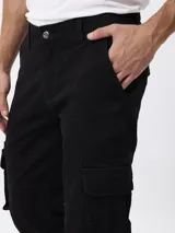 Pantalon cargo de gabardina color negro, con corte regular fit, tiro medio, cierre de boton y cremallera, y bolsillos laterales tipo cargo.