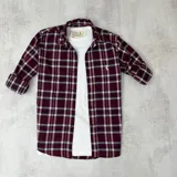 Camisa de manga larga color bordó con estampado a cuadros en blanco y gris.