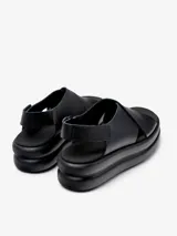 Sandalias negras de cuero vacuno con plataforma gruesa y tiras cruzadas.