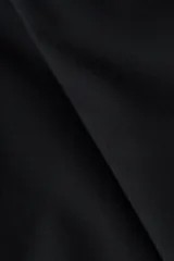 Pantalón sastrero de tiro alto y color negro, con piernas rectas, raya marcada al frente y bolsillos laterales al bies.