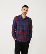 Camisa masculina de franela a cuadros en tonos rojo y azul, de corte comfort, con cuello camisero, manga larga y abotonadura frontal.