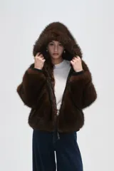Campera bomber negra con cuello de piel sintética marrón, cierre frontal con cremallera y puños elásticos.