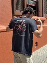 Camiseta blanca de manga corta con estampado en la espalda de una flor de hibisco azul y la frase "Where hibiscus grows, peace flow".