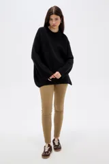 Sweater de punto negro, con cuello redondo a la base, manga larga y diseño holgado.