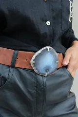 Cinto de cuero azul con hebilla circular de piedra ágata con borde dorado.