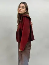 Buzo de lana merino afieltrada con diseño artesanal de efecto degradado en tonos violeta y fucsia. Presenta cuello alto, hombreras marcadas y corte holgado.