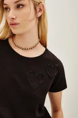 Remera de algodón color marrón oscuro con escote en V y dos apliques bordados en forma de corazón en el frente.