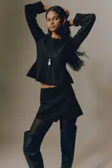 Short pollera de sarga color negro, diseño cruzado tipo envolvente en el frente y ajuste entallado.