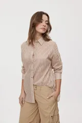 Camisa de rayas de calce relajado, confeccionada en tejido liviano y semitransparente, con cuello clásico, cierre frontal con botones, mangas largas con puños y hombros caídos.