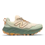 Championes de trail running New Balance Fresh Foam X Hierro v9, color crema con detalles en verde y naranja. Cuentan con entresuela Fresh Foam X de doble densidad, suela Vibram® Megagrip™ con tecnología Traction Lug™ y tecnología Toe Protect.