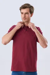Remera polo de piqué azul marino, con cuello y puños de mangas cortas con ribete blanco en contraste, cierre frontal de dos botones y pequeño logo bordado en el pecho.