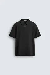 Polo de corte regular fit color negro, confeccionado en tejido de algodón con textura de rayas verticales, cuello solapa, cierre frontal de dos botones y mangas cortas con ribetes en los puños.