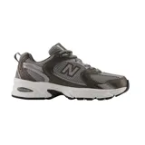 Championes urbanos New Balance modelo 530, con diseño retro inspirado en el running. Presentan una combinación de malla transpirable y superposiciones sintéticas en tonos gris oscuro y metalizado, con entresuela blanca equipada con tecnología ABZORB para mayor amortiguación.