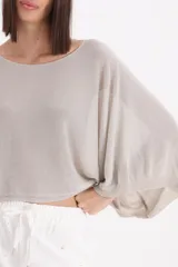 Sweater de punto con acabado metalizado, diseño de mangas tipo murciélago y corte holgado.