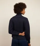 Campera deportiva negra confeccionada en microfibra pesada, con cuello alto doblado, cremallera delantera con cordón en el tirador y puños ajustados.