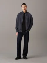 Sweater azul con textura tipo waffle, cuello alto, cierre frontal con cremallera metálica, puños y bajo acanalados, y logo pequeño en el pecho.