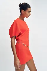 Falda corta de punto con cintura elástica y diseño en evasé de color rojo.