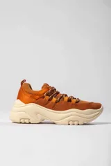 Championes de caña baja color marrón, con detalles en naranja y suela chunky color crema.