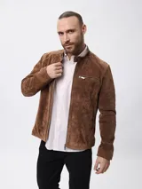 Campera biker de cuero color marrón, con cuello mao, cierre frontal metálico, bolsillo en el pecho con cierre y bolsillos laterales.