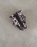 Zapatillas deportivas de cuero vacuno con estampado animal print de vaca en blanco y marrón.