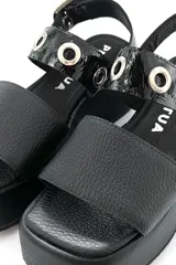 Sandalia negra de cuero con plataforma y ajuste con hebilla.