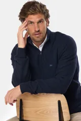 Buzo azul marino de algodón texturizado, con cuello alto y medio cierre con cremallera. Presenta un pequeño logo bordado en el pecho.