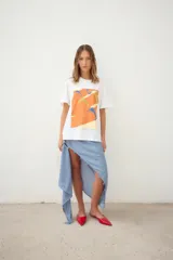 Remerón oversize de algodón blanco con estampado frontal de dos mujeres en bikini, con texto "Muertas de calor, cu pa arriba. Amiga hacerme un lugar. Desátame la bikini. Me quedo la marca? Pásame el Hawaiian. Eterno enero."