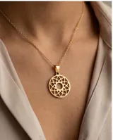Dije circular de acero con baño de oro, con diseño calado geométrico tipo mandala.
