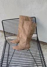 Botas altas de gamuza color beige, con punta fina y taco fino bajo tipo kitten heel.