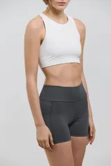 Minishort deportivo de tiro alto con bolsillos laterales, confeccionado en tejido elastizado de compresión media.