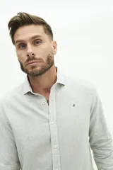 Camisa de manga larga de lino y algodón, color blanco con rayas verticales en tonos gris y beige. Presenta un corte semi slim y un pequeño logo bordado en el pecho.