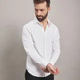 Camisa de vestir blanca de manga larga, confeccionada en tejido técnico libre de arrugas, con cuello clásico y cierre frontal de botones.
