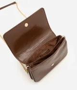 Cartera bandolera Satinato pequeña de color marrón oscuro, confeccionada en poliuretano con detalles de herrajes dorados y correa larga de cadena. Cuenta con solapa frontal y múltiples compartimentos internos.