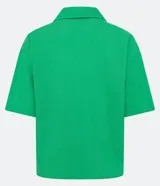 Camisa de manga corta confeccionada en mezcla de viscosa y lino color turquesa. Presenta cuello camisero con escote en V, bolsillos frontales de parche y cierre frontal con botones geométricos de efecto carey.