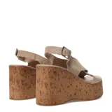 Sandalias de plataforma alta tipo cuña con acabado de corcho. Presentan tiras cruzadas en el empeine confeccionadas en gamuza color beige y una pulsera ajustable con hebilla metálica en el tobillo.