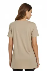 Remera de algodón gris con cuello redondo y mangas cortas. Presenta un estampado frontal con formas abstractas y motivos botánicos en tonos azul, beige y verde.
