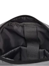 Bolso tipo morral de la marca Caterpillar, color gris, con correa ajustable para el hombro, compartimento principal con cierre, bolsillo frontal con cremallera y logo de la marca en el frente.