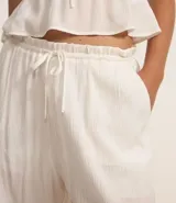 Pantalón recto de viscosa color bordó, con superficie texturizada y lazo ajustable en la cintura.