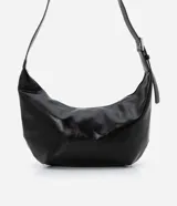 Bolso modelo hobo de gran tamaño, confeccionado en poliuretano con acabado que imita el cuero. Presenta una forma de media luna, cierre superior con cremallera y una correa de hombro ajustable con hebilla metálica.