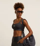 Top deportivo color gris oscuro con copas, breteles finos con lettering y estampado frontal "Sporty".