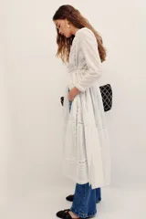 Camisa larga blanca de algodón estilo túnica, con detalles de encaje y bordados en el frente y mangas largas.
