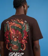 Remera marrón de algodón con cuello redondo y mangas cortas. Estampa en la espalda con diseño de máscara japonesa, serpiente, espadas y flores. Estampa frontal con la frase "Honor and Duty".