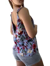 Blusa celeste con estampado de flores rojas, amarillas y hojas verdes, con breteles finos que se atan en los hombros.