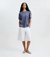 Remera de corte boxy con cuello redondo y mangas cortas. Confeccionada en algodón, presenta un diseño minimalista sin estampas con sisa caída.