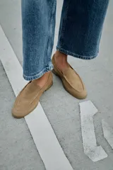 Mocasín plano de mujer confeccionado en serraje, con diseño de punta redonda, copete subido y suela con efecto engomado.
