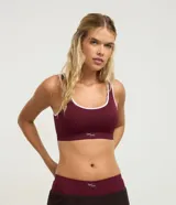 Soutien tipo top texturizado de color bordó, sin aros ni copas, con tirantes medianos y detalles de ribetes en color blanco.
