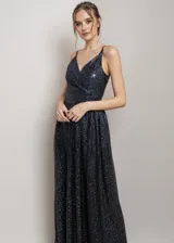 Vestido largo de fiesta con escote en V cruzado y tirantes finos. Confeccionado en tela negra con acabado de glitter brillante, presenta un corte entallado en la cintura y falda con caída fluida.
