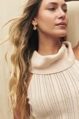 Musculosa blanca de tejido de punto calado, con cuello alto tipo polera y corte ajustado.